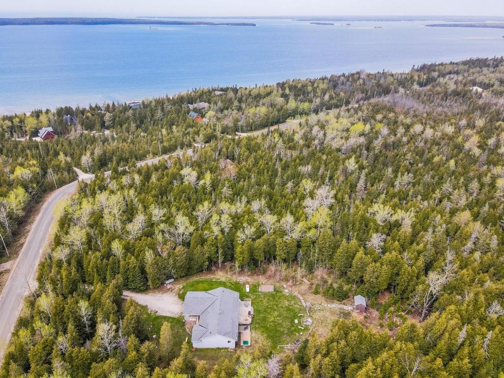 莱昂斯黑德Huron retreat, near beach & pet friendly的大海旁山丘上房屋的空中景观