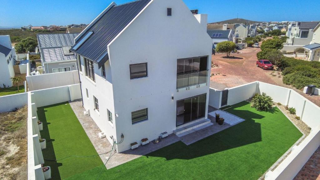 an aerial view of a white house with a yard at Wine Not Relax in Yzerfontein