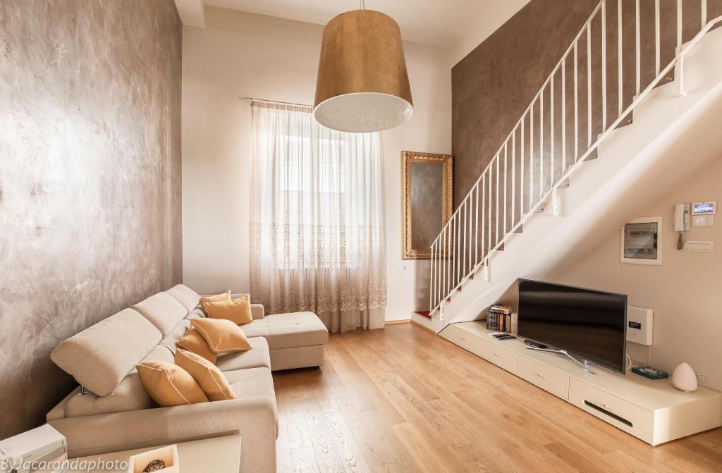a living room with a couch and a tv at Gold Apartment Viareggio in Viareggio
