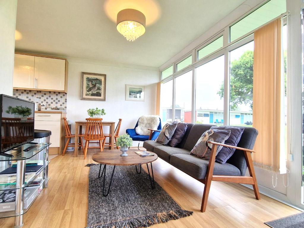 a living room with a couch and a table at 93 Broadside Holiday Chalet near Broads & Beaches in Stalham