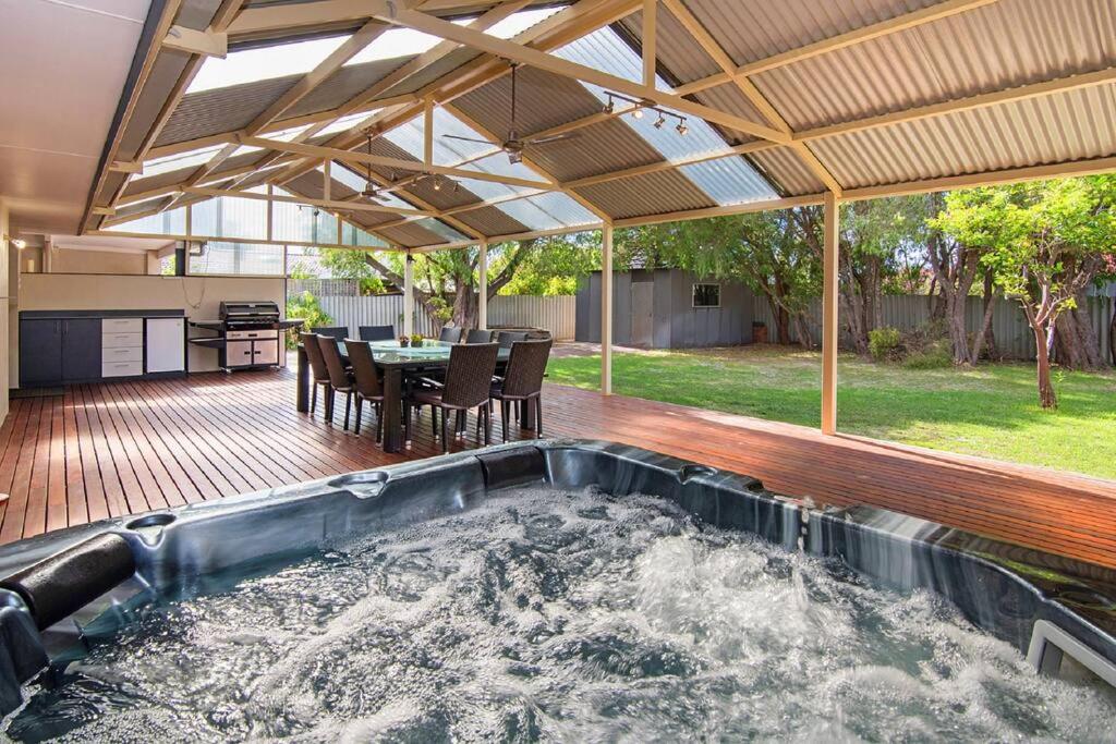 a hot tub in the middle of a patio with a table at Haven By the Bay- Short walk to Broadwater beach in Broadwater