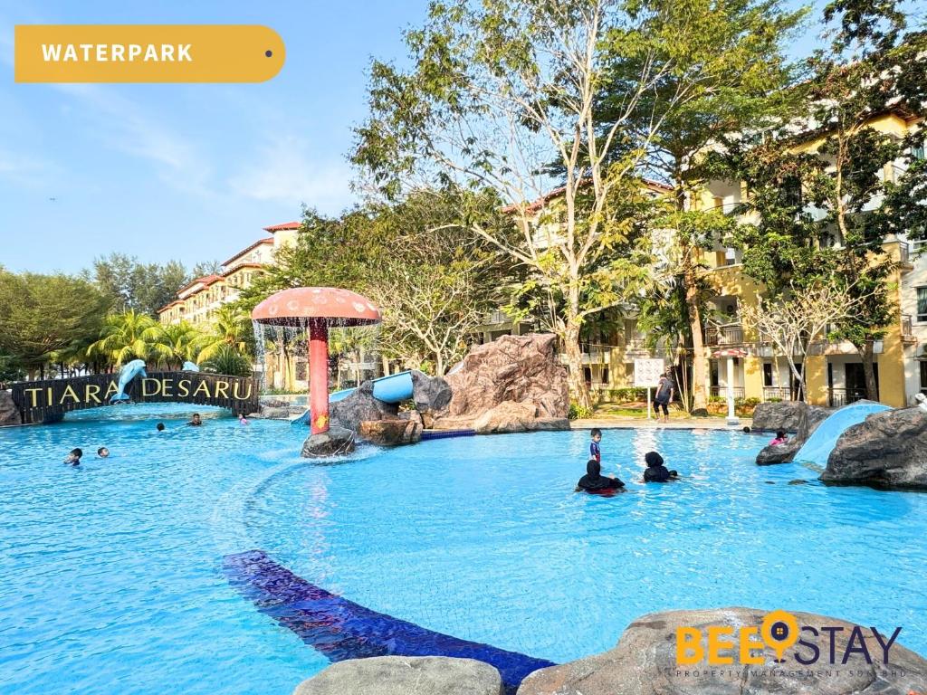 a pool at a water park with people in it at Desaru Tiara Beach Resort Pool View 3-5PAX in Bandar Penawar