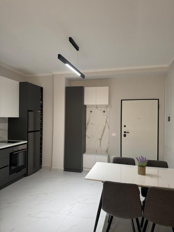 a kitchen with a table and chairs in a room at DG Apartment in Golem