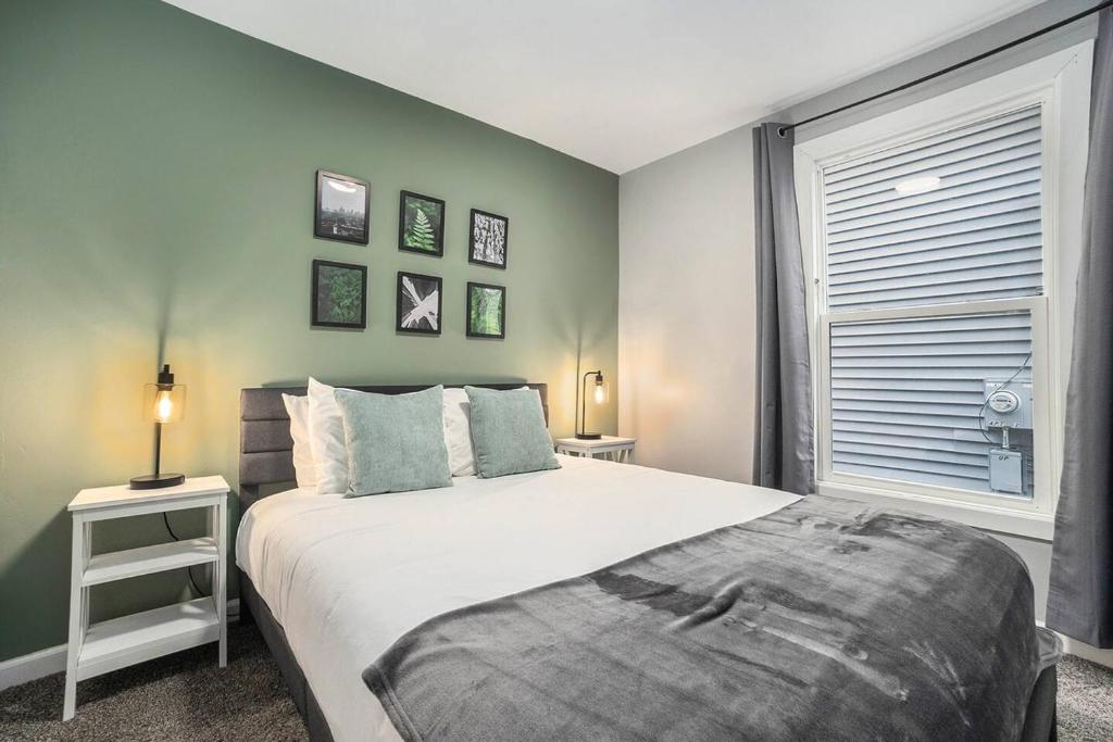 a bedroom with a large bed and a window at The Downtown Delight - New Corporate Apt Downtown in Grand Rapids