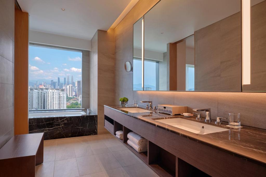A spacious double-sink bathroom has a skyline window beside the vanity.