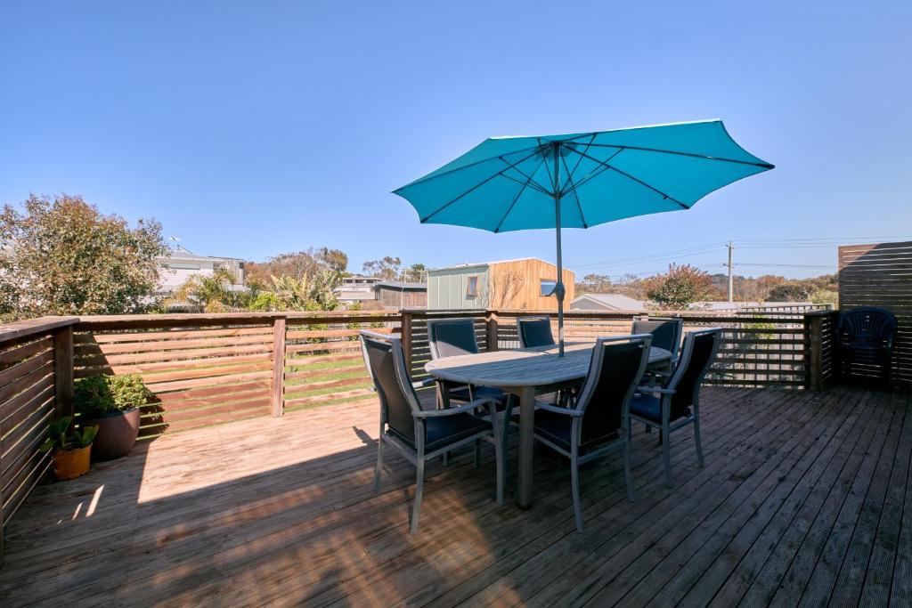 a table with chairs and an umbrella on a deck at Bird Rock Shack 200m to beach and pet friendly in Torquay