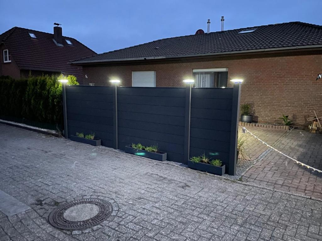 a black fence in front of a house at Ferienhaus Gomann in Dornum