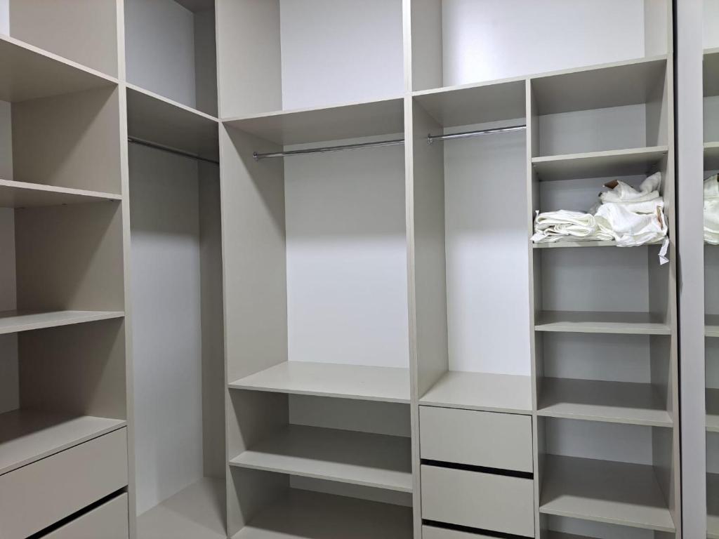 a white walk in closet with white shelves at Sea Breeze in Nardaran