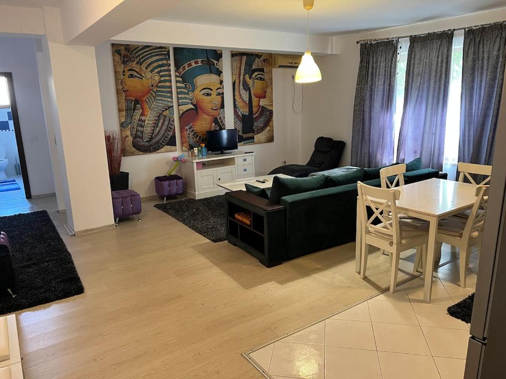a living room with a green couch and a table at Apartament Mamaia-Nord 5min de mers pe plaja in Mamaia Nord