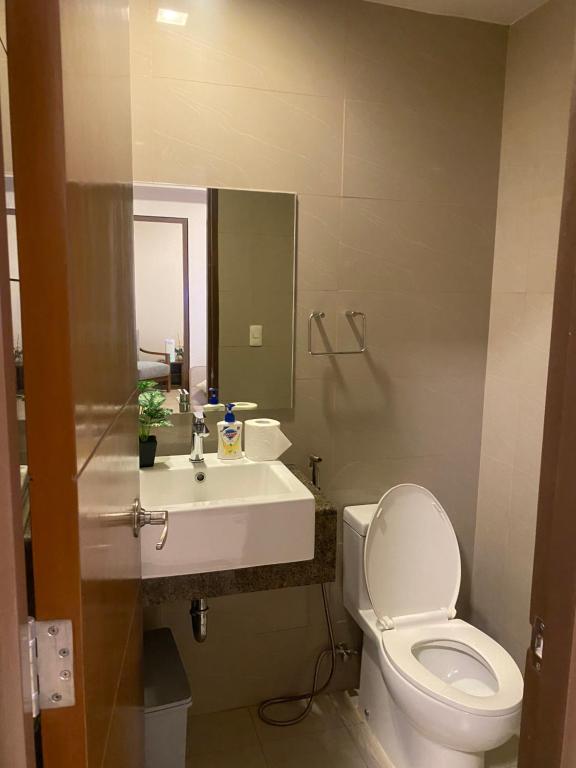 a bathroom with a white toilet and a sink at The Mactan Newtown Beach Condo in Lapu Lapu City