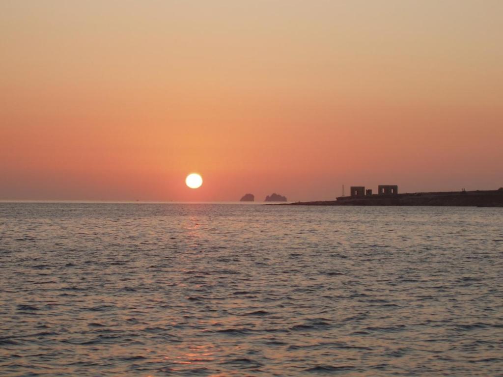 un tramonto sull'oceano con il sole che tramonta di PAROS APARTMENT MELAS b2 a Paroikia