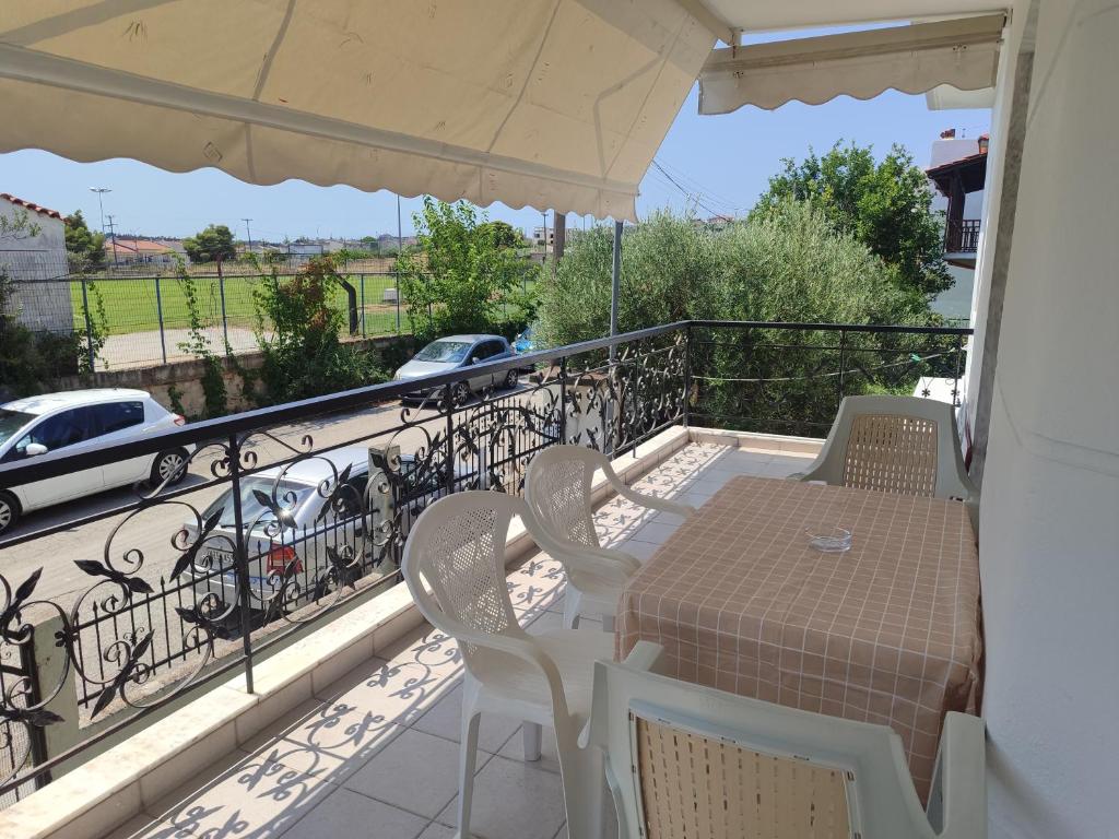 a balcony with a table and chairs and an umbrella at Elena's Apartment in Nea Fokea