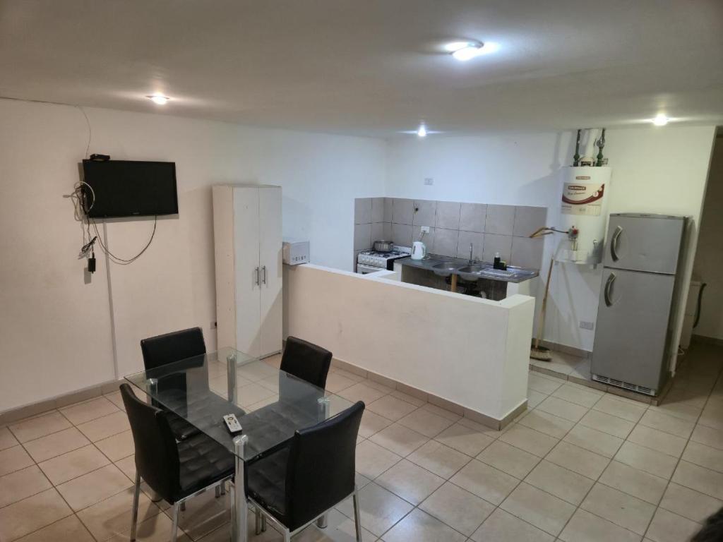 a room with a table and a kitchen with a refrigerator at Alquiler por día Río Gallegos in Río Gallegos