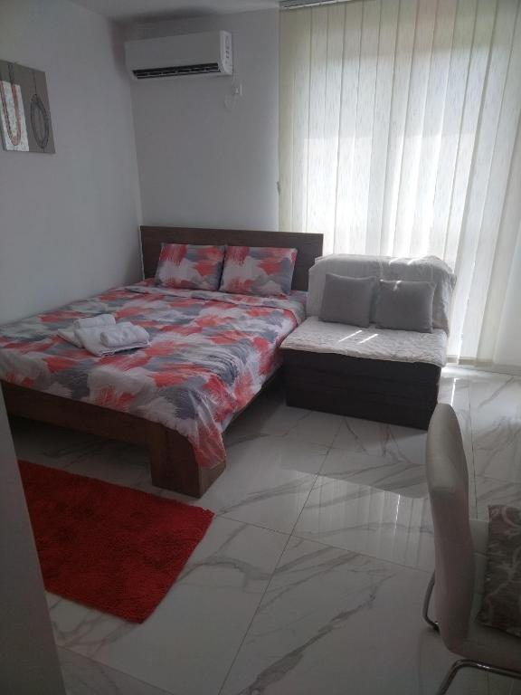 a bed and a couch in a room at Apartman Markovic Silver Lake in Veliko Gradište