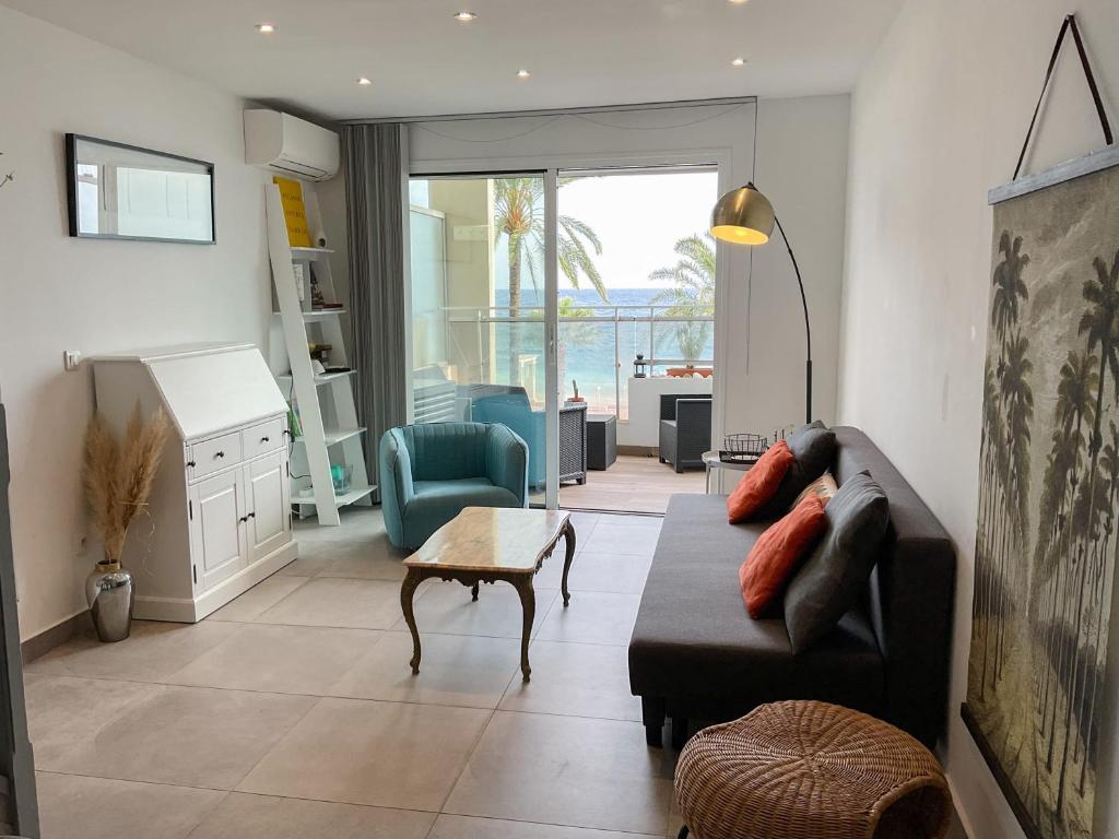 una sala de estar con un sofá y una mesa en La Prom 2 - a two bedroom apartment with a sea view, en Niza