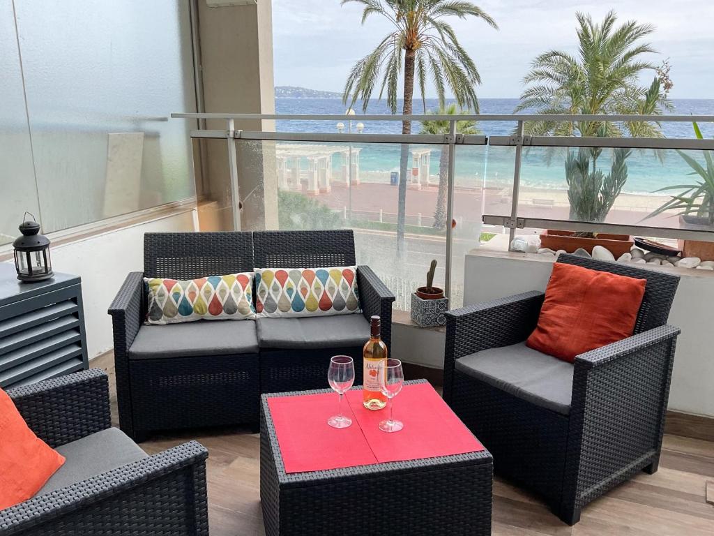 a living room with chairs and a table with wine glasses at La Prom 2 - a two bedroom apartment with a sea view in Nice