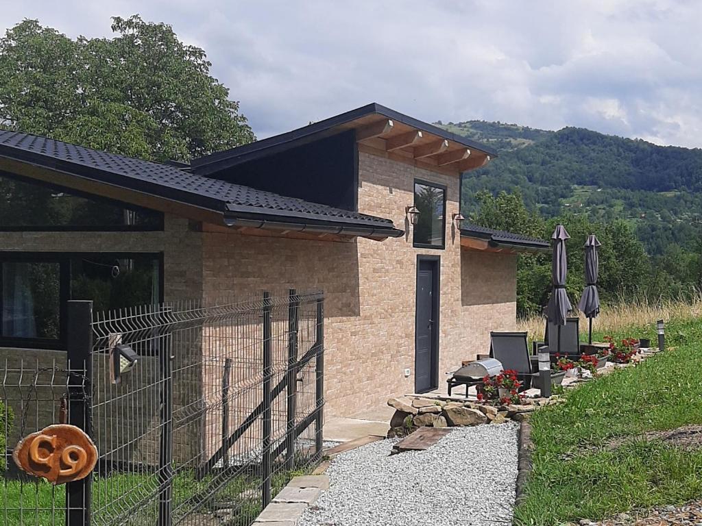 a small house with a fence in front of it at Casa nouă in Vişeu de Sus