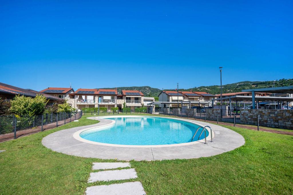 a swimming pool in the middle of a yard at ApartmentsGarda - Garda31 Residence in Garda