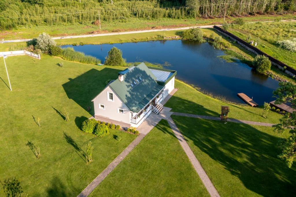 eine Luftaufnahme eines weißen Hauses auf einem Feld mit einem See in der Unterkunft Elegant Conference room at Sinso Talu in Ülejõe