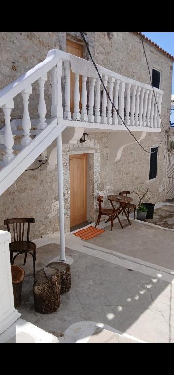 a patio with a white staircase and tables and benches at Papu's Villa in Piqeras