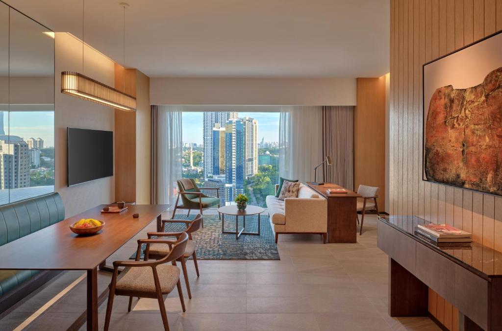A generous suite-style living area with dining, lounge seating and a city view.