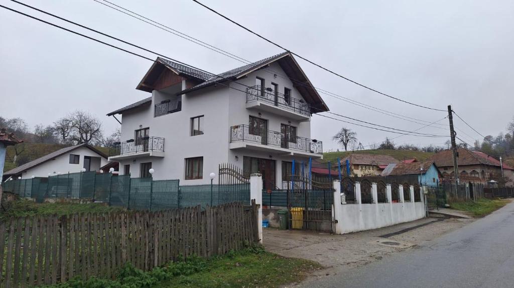 a white house with a fence in front of it at Casa Bella in Cicanesti