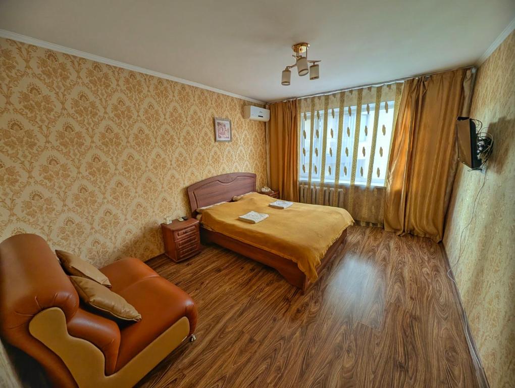 a bedroom with a bed and a chair and a window at Cozy flat apartment in Chişinău