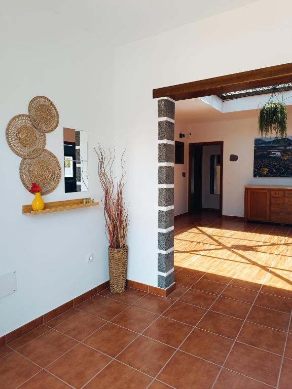 a living room with a tile floor and a wall at Casa Rinaifi in Guatiza