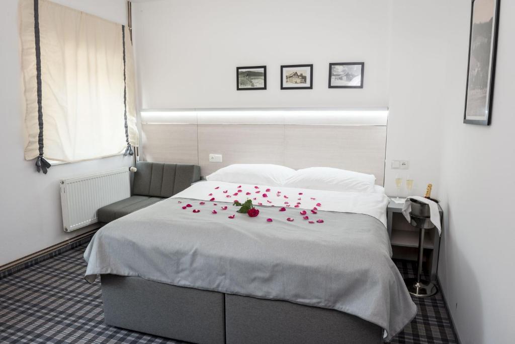 a bedroom with a bed with red roses on it at Horský Hotel Dobrá Chata in Stachy