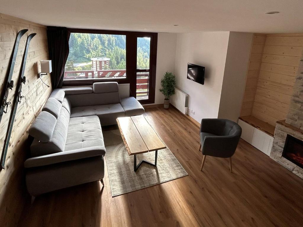un salon avec un canapé et une table dans l'établissement Spacieux appart rénové, 3 pièces + cabine, proche pistes, 8 pers, animaux admis - FR-1-181-1913, à La Plagne Tarentaise
