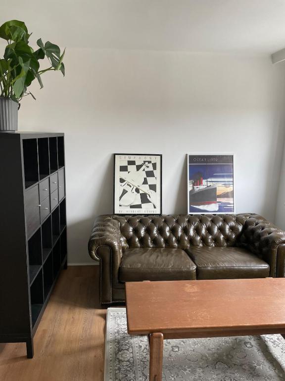a living room with a leather couch and a table at Schöne Wohnung in Bahnhofsnähe in Wels