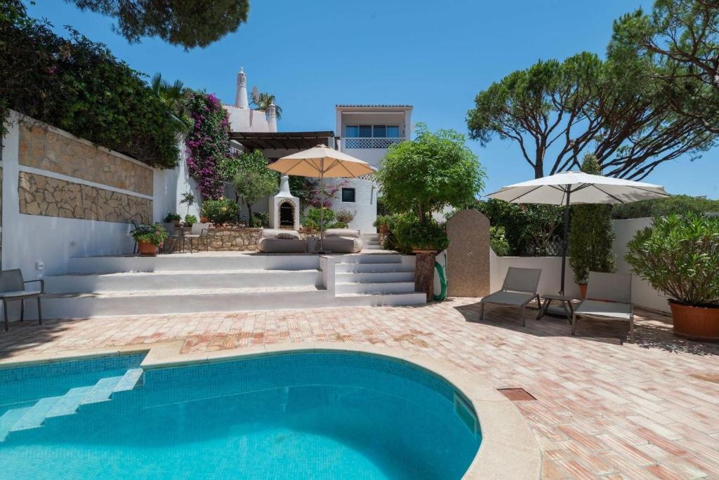 a swimming pool in front of a house at Vila Antic in Almancil