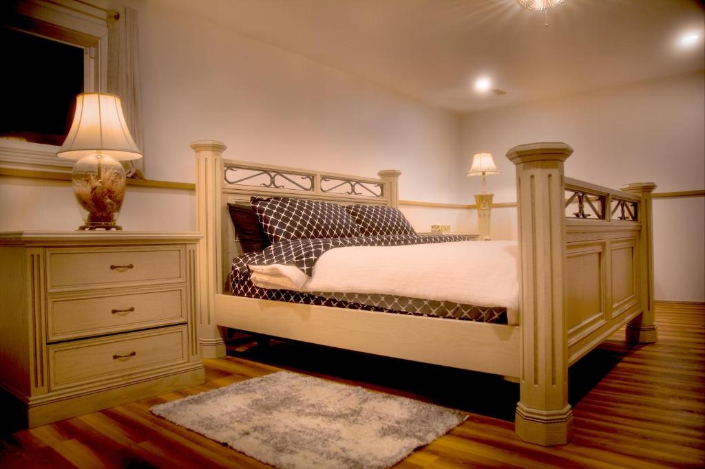 a bedroom with a bed and a dresser and lamp at Spacious vintage styled basement apartment - private in Calgary