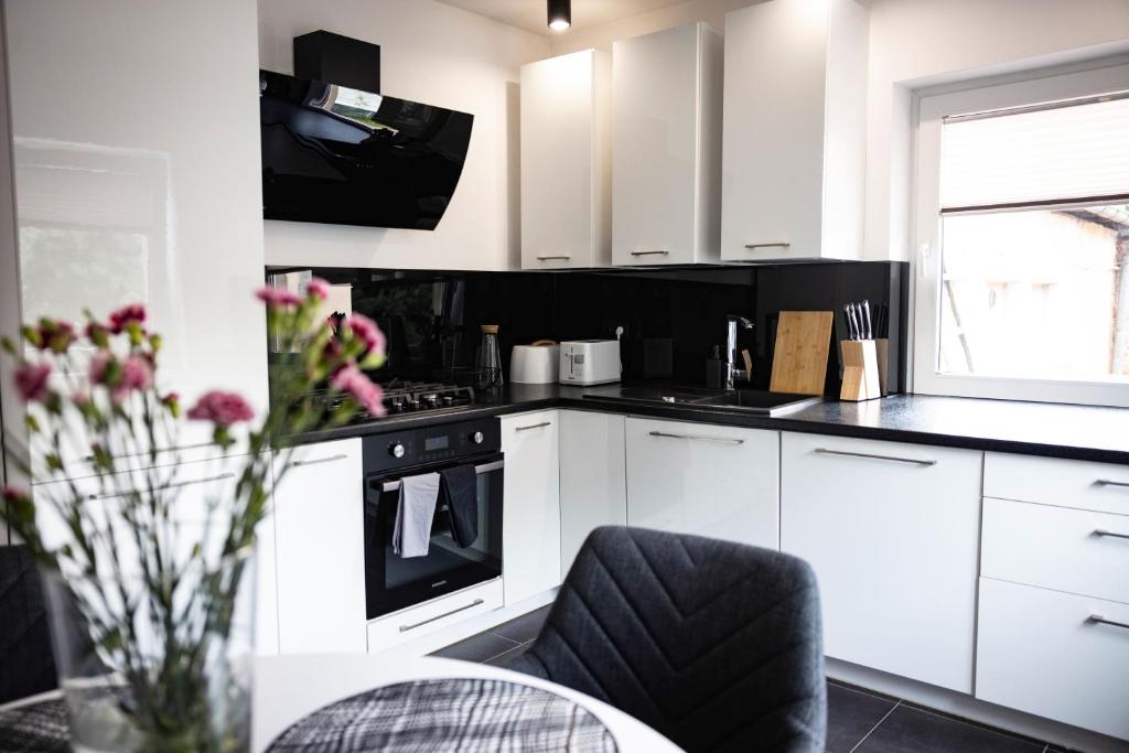 una cucina con mobili bianchi e un forno a piano cottura di Apartament Perła w Kłodzku a Kłodzko