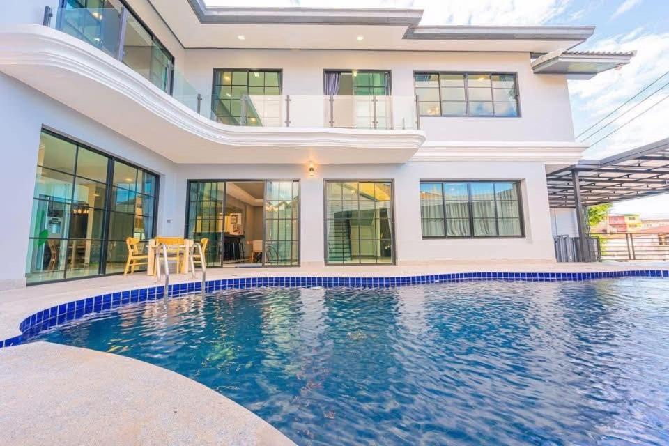 una casa con piscina delante de una casa en BoomVilla 2, en Pattaya South