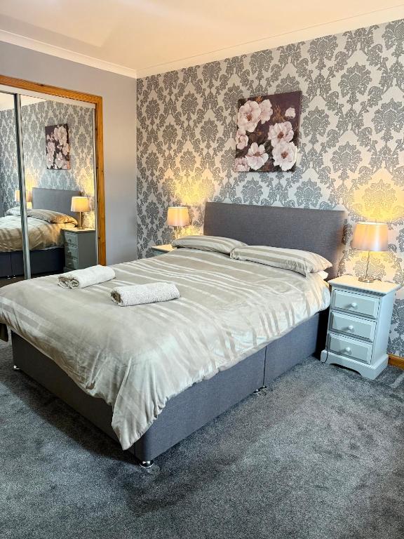 a bedroom with a large bed and a mirror at The Old Salt House, Flat 2 in Wick