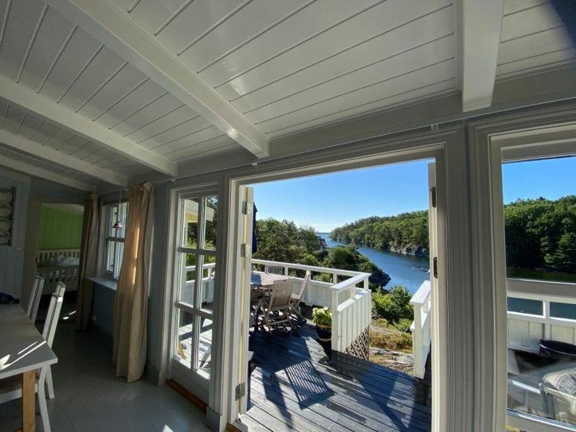 a house with a balcony with a view of a river at Pollyville in Lillesand