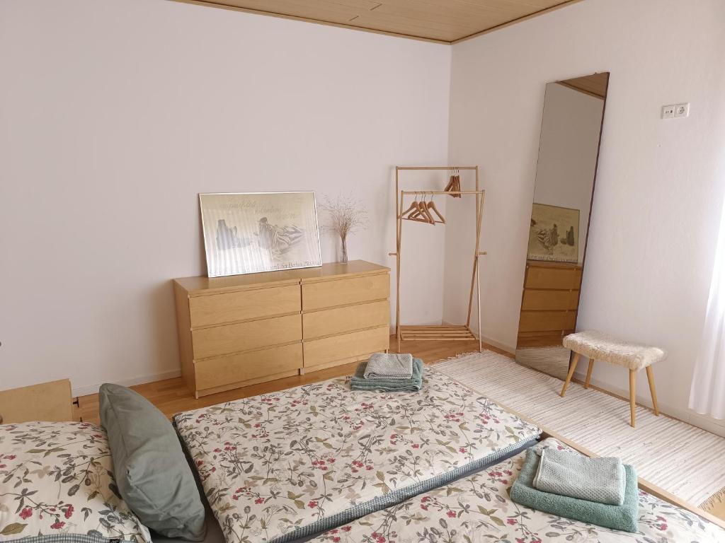a bedroom with a bed and a dresser and a mirror at Ferienwohnung am Kurwald, Nähe Kliniken, 88qm, Parkplatz in Bad Lippspringe