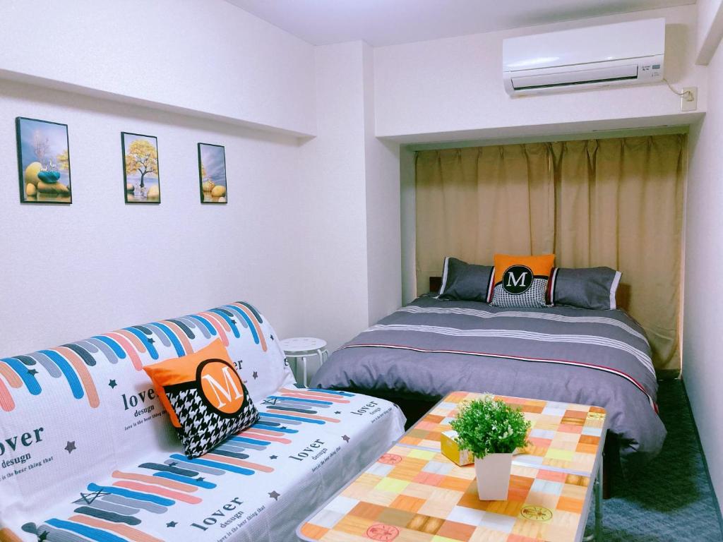 um quarto com duas camas, uma mesa e um sofá em Shinjuku House-1 em Tóquio
