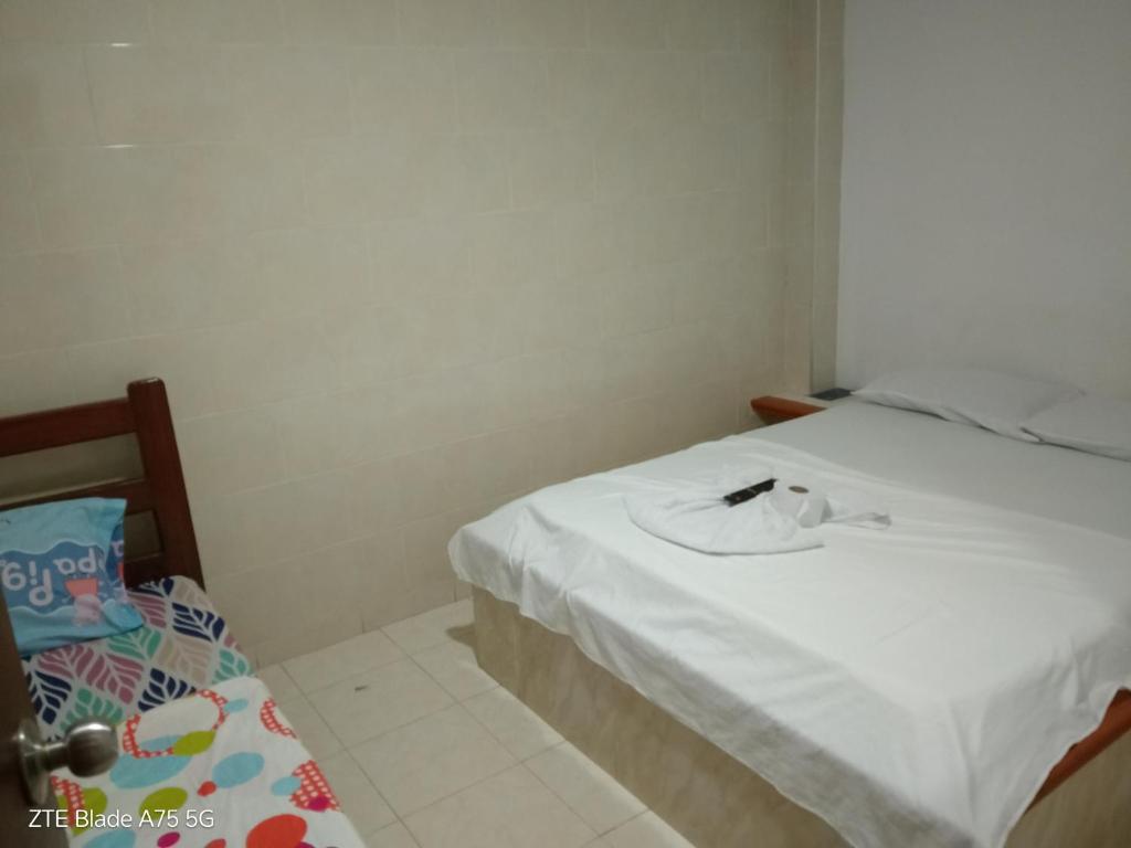 a room with a bed with a white sheets and a pillow at Hospedaje el balcon suite in Villavicencio
