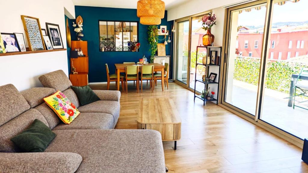 un salon avec un canapé et une table dans l'établissement Appartement 90m2, climatisé 3 chambres, à Nice
