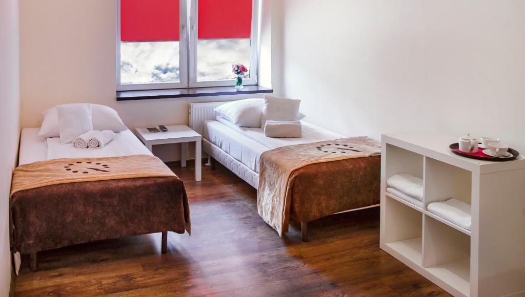 Habitación con 2 camas y sofá. en Boutique Hostel en Lodz
