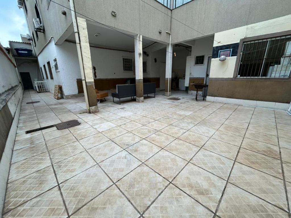 einen leeren Innenhof eines Gebäudes mit Stühlen und Tischen in der Unterkunft Casa Vila Santa Cecília - No Centro da Cidade in Volta Redonda