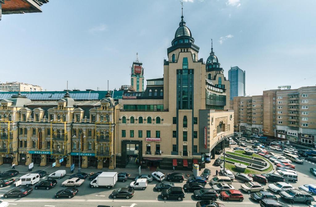 a busy city with cars parked in a parking lot at Apartment Arena City in Kyiv