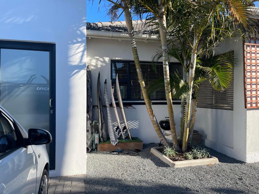 a car parked in front of a house with a palm tree at Nahoon Studio A in East London