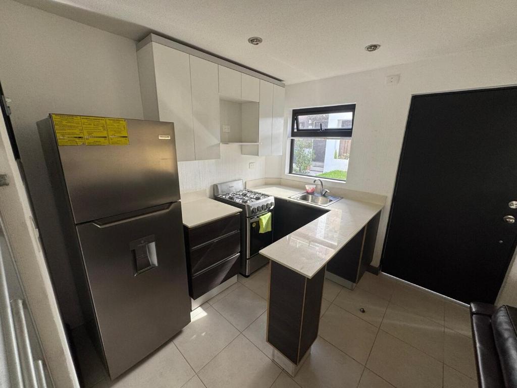 a kitchen with a stainless steel refrigerator and a sink at House in Álika Club Residencial in Fraijanes