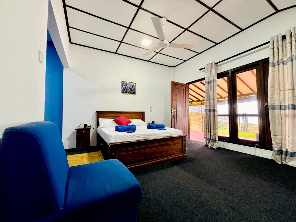 een slaapkamer met een bed, een bank en een raam bij Sea Breeze Stay in Negombo