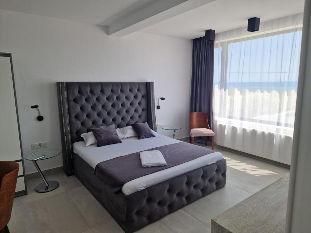 a bedroom with a large bed with a large window at Suite Pool Golful Francez in Schitul