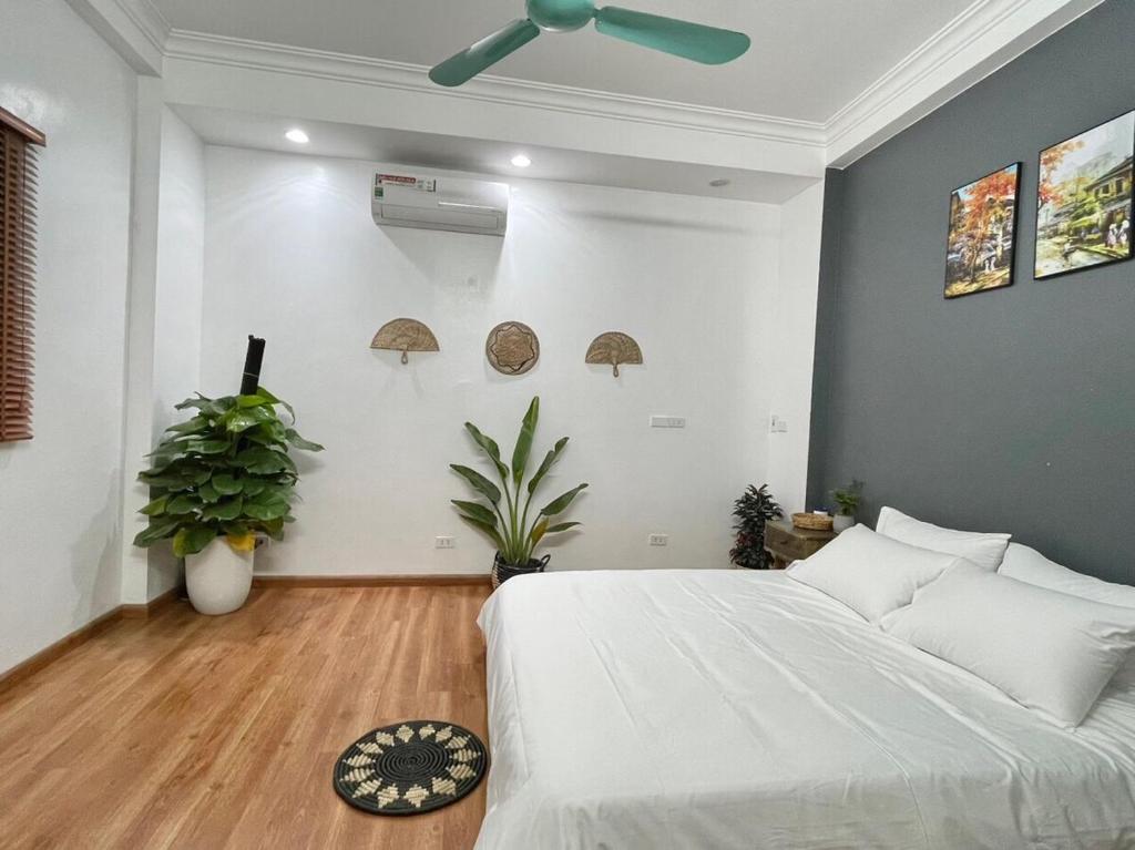 une chambre avec un lit et un ventilateur de plafond dans l'établissement The Little Ha Noi 5 Bedrooms Large Yard Balcony, à Hanoï
