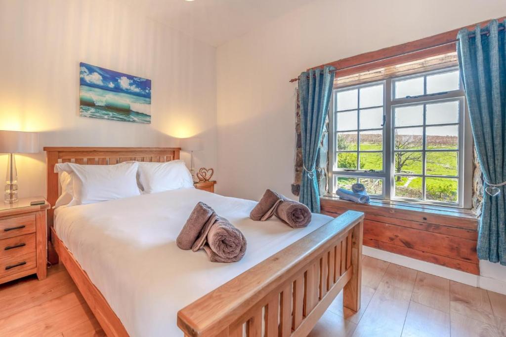 a bedroom with a large bed and a window at Pembrokeshire Near Beach With A Hot Tub in Pembroke